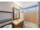 Bright bathroom featuring a wood vanity, lighted mirror, and tiled shower-tub combo at 10373 54Th N Ave, St Petersburg, FL 33708