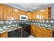 Kitchen featuring sleek black appliances, wooden cabinetry, and stylish countertops at 10373 54Th N Ave, St Petersburg, FL 33708