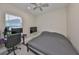 A simple bedroom setup featuring a bed, desk, and a view from the window in a modern style at 11008 Sand Pine Ln, Parrish, FL 34219