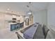 Open kitchen and dining area with a long table that seats six, white cabinets and a large kitchen island at 11008 Sand Pine Ln, Parrish, FL 34219