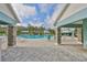 View of the resort-style community pool showcasing the covered seating area and lush landscaping with palm trees at 11008 Sand Pine Ln, Parrish, FL 34219