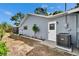 Side view of home with white door, new A/C unit, and minimal landscaping in mulched flower bed at 11283 Portsmouth St, Spring Hill, FL 34609