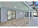 Covered and tiled patio leads to screened pool enclosure through sliding doors at 11283 Portsmouth St, Spring Hill, FL 34609