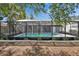 Backyard view showcasing a screened pool with a clean patio deck, perfect for relaxation and entertaining at 11283 Portsmouth St, Spring Hill, FL 34609