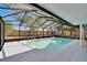 Relax in this enclosed pool with screened enclosure and lush backyard views at 11283 Portsmouth St, Spring Hill, FL 34609