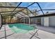 Enclosed pool with screened enclosure, tiled patio and view of the backyard at 11283 Portsmouth St, Spring Hill, FL 34609