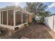 Backyard showcasing a screened patio, brick pavers, lush greenery, and a privacy fence at 11351 130Th Ave, Largo, FL 33778