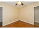 Standard bedroom with hardwood floors, baseboard trim, and a ceiling fan and an open doorway at 11351 130Th Ave, Largo, FL 33778