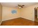 Bedroom features hardwood floors, window with blinds, and ceiling fan with light at 11351 130Th Ave, Largo, FL 33778