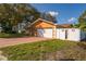 Exterior of home with a white garage door, fenced yard, and lush green lawn at 11351 130Th Ave, Largo, FL 33778
