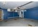 This garage is painted with a modern blue accent wall and has epoxy floors at 11351 130Th Ave, Largo, FL 33778