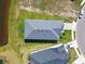 Aerial view of a well-maintained house with a gray roof, green lawn, and a serene pond nearby at 11912 Richmond Trl, Parrish, FL 34219