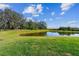 Expansive backyard featuring lush green lawn and serene pond views at 11912 Richmond Trl, Parrish, FL 34219
