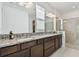Bright bathroom featuring double sinks, granite counters, and a glass-enclosed walk-in shower at 11912 Richmond Trl, Parrish, FL 34219