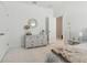 Light-filled bedroom featuring a white dresser, mirror, and plush neutral carpet at 11912 Richmond Trl, Parrish, FL 34219