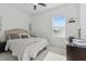 Bright bedroom with a neutral bed frame, pillows, and side table with a decorative lamp at 11912 Richmond Trl, Parrish, FL 34219