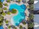 A unique aerial perspective shows the guitar-shaped community pool surrounded by lush landscaping and lounge areas at 11912 Richmond Trl, Parrish, FL 34219