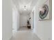 Long foyer with white tile floors, bench, and modern artwork offers a welcoming feel at 11912 Richmond Trl, Parrish, FL 34219