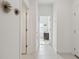 Bright hallway with neutral tile flooring, white walls and doors, and decorative metal accents at 11912 Richmond Trl, Parrish, FL 34219