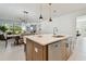 Kitchen island with quartz countertop, stainless steel dishwasher, and an open view of the dining area at 11912 Richmond Trl, Parrish, FL 34219