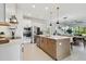 Island kitchen featuring stainless steel appliances, quartz countertops, and island with barstool seating at 11912 Richmond Trl, Parrish, FL 34219