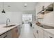 Bright kitchen with stainless steel appliances, white cabinets, and an open view to the living room at 11912 Richmond Trl, Parrish, FL 34219