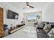Bright living room with a ceiling fan, plush sofa with decorative pillows, and large screen television at 11912 Richmond Trl, Parrish, FL 34219