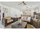Bright living room with wicker furniture, neutral colors, ceiling fan, and open layout to dining and kitchen at 11912 Richmond Trl, Parrish, FL 34219