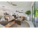 Open living area with a large plant, wicker furniture, and views of the dining room and outdoor space at 11912 Richmond Trl, Parrish, FL 34219
