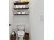 Compact half bathroom with a toilet, floating shelves, and a basket for storage at 11912 Richmond Trl, Parrish, FL 34219