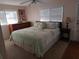 Bedroom features a large bed, dresser, nightstand, and two windows for natural light at 126 Colonial Blvd # 7, Palm Harbor, FL 34684