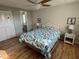 Bright bedroom featuring hardwood floors, turtle art, ceiling fan, and ensuite bathroom at 13225 101St St # 393, Largo, FL 33773