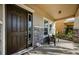 Welcoming front porch with stone accents, neutral paint, and a cozy sitting area with decorative glass windows at 13452 Canopy Creek Dr, Tampa, FL 33625