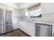 Modern kitchen with stainless steel appliances, granite counters, and sleek white cabinets at 14511 Catalina Cir # 14511, Seminole, FL 33776