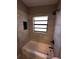 Bathroom featuring a tub with a shower head, tiled walls, and modern black fixtures at 1501 Howard Pl, Largo, FL 33770