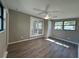 Bright bedroom with wood-look floors, ceiling fan, and glass panel doors leading to outdoor space at 1501 Howard Pl, Largo, FL 33770
