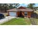Charming single-story home with a manicured lawn, fenced yard, and attached garage at 15429 Green Jay Rd, Weeki Wachee, FL 34614