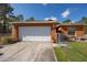 Attached two-car garage with manicured lawn and charming single-story home at 15429 Green Jay Rd, Weeki Wachee, FL 34614