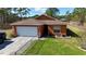 Charming single-story home with a manicured lawn, fenced yard, and attached garage at 15429 Green Jay Rd, Weeki Wachee, FL 34614
