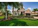 Charming home with a well-manicured lawn, mature palm trees, and colorful flower beds at 1602 Abyss Dr, Odessa, FL 33556