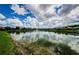 Scenic view of a community pond with a fountain and residential houses in the background at 1602 Abyss Dr, Odessa, FL 33556