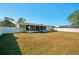 A large backyard is surrounded by a white fence, lush lawn, and tropical plants at 18350 Burkholder Cir, Port Charlotte, FL 33948