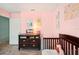 Bedroom bedroom with pink walls, crib, and dark dresser at 18350 Burkholder Cir, Port Charlotte, FL 33948