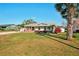 Charming single-story home with a well-manicured lawn and vibrant landscaping at 18350 Burkholder Cir, Port Charlotte, FL 33948