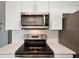 Updated kitchen with stainless steel appliances, white cabinets, and stylish backsplash, blending modern amenities at 18350 Burkholder Cir, Port Charlotte, FL 33948