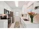 Modern, well-lit kitchen featuring white cabinets, updated appliances, and a view of the outdoors at 18350 Burkholder Cir, Port Charlotte, FL 33948