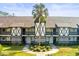 Exterior of a Tudor-style condo building with a well-maintained lawn and a palm tree in the front at 210 N Bayshore Blvd # 104, Clearwater, FL 33759