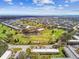 An aerial view of low-rise condos on a golf course surrounding a pond with mature landscaping at 2280 World Parkway Blvd # 34, Clearwater, FL 33763