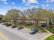 Exterior view of a condo community with parking spaces, green spaces and mature trees at 2280 World Parkway Blvd # 34, Clearwater, FL 33763