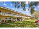 Charming condo building with well-kept lawns, trees, and outdoor seating at 2280 World Parkway Blvd # 34, Clearwater, FL 33763